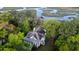 Aerial view of waterfront property with lush trees surrounding a beautiful home and private dock at 8374 Chisolm Plantation Rd, Edisto Island, SC 29438