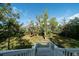 View from the back deck of the grassy and woodsy backyard, perfect for enjoying nature and privacy at 8374 Chisolm Plantation Rd, Edisto Island, SC 29438
