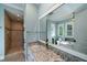 A well-lit bathroom featuring a double sink with granite countertop, walk-in shower and tub at 8374 Chisolm Plantation Rd, Edisto Island, SC 29438