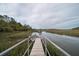 Walking along a wooden walkway to a private pier with a covered gazebo offering an amazing marsh view at 8374 Chisolm Plantation Rd, Edisto Island, SC 29438