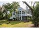 View of a charming house with a large back porch and landscaped yard at 8374 Chisolm Plantation Rd, Edisto Island, SC 29438