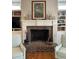 Living room with a brick fireplace, decorative mantle, and built-in bookshelves at 8374 Chisolm Plantation Rd, Edisto Island, SC 29438