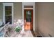 Charming front door with decorative glass and sidelight is accented by flowers and a window at 8374 Chisolm Plantation Rd, Edisto Island, SC 29438