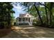 Charming home featuring a welcoming porch and landscaped front yard with mature trees at 8374 Chisolm Plantation Rd, Edisto Island, SC 29438