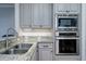 Beautiful kitchen features gray cabinets, stainless steel appliances, and granite countertops at 8374 Chisolm Plantation Rd, Edisto Island, SC 29438