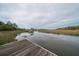 Enjoy a beautiful marsh view from a private wooden dock with a pier for watching wildlife and spectacular sunsets at 8374 Chisolm Plantation Rd, Edisto Island, SC 29438
