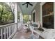 Relaxing porch featuring comfortable wicker furniture, ceiling fan, and a view of the surrounding greenery at 8374 Chisolm Plantation Rd, Edisto Island, SC 29438