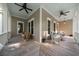 Inviting covered porch with ceiling fans, swing, white wicker furniture, and beautiful wood flooring at 8374 Chisolm Plantation Rd, Edisto Island, SC 29438