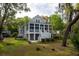 Elevated home featuring a backyard with a spacious deck overlooking the landscaped yard and mature trees at 8374 Chisolm Plantation Rd, Edisto Island, SC 29438