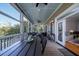 Outdoor dining area on a screened porch, with a view of a wooded landscape at 8374 Chisolm Plantation Rd, Edisto Island, SC 29438