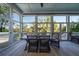 Screened porch with a dining table and chairs, offering a view of the surrounding trees at 8374 Chisolm Plantation Rd, Edisto Island, SC 29438
