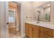 Bathroom with a wooden vanity, granite countertop, and a doorway leading to a glass-enclosed shower at 8409 Hidden Bakers Trce, North Charleston, SC 29418
