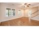 Well-lit living room featuring hardwood floors, multiple windows, a ceiling fan, and fresh paint at 8409 Hidden Bakers Trce, North Charleston, SC 29418