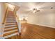 Bright open-concept living area featuring hardwood floors, neutral walls, and a staircase leading to the upper level at 8409 Hidden Bakers Trce, North Charleston, SC 29418