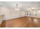 Open living and dining area with hardwood floors, neutral paint, and a classic chandelier at 8409 Hidden Bakers Trce, North Charleston, SC 29418