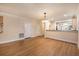 Spacious living area featuring hardwood floors, neutral walls, and convenient access to the kitchen and other rooms at 8409 Hidden Bakers Trce, North Charleston, SC 29418