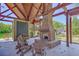 Inviting outdoor lounge area featuring a brick fireplace, wood beam roof and comfortable seating at 8409 Hidden Bakers Trce, North Charleston, SC 29418