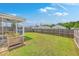 Large, grassy backyard with a wooden fence, complemented by a screened porch for outdoor living at 9707 Seed St, Ladson, SC 29456