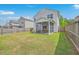 Expansive backyard features a lush lawn, a wooden fence, and a screened porch, ideal for outdoor gatherings at 9707 Seed St, Ladson, SC 29456