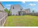 Spacious backyard with a well-maintained lawn, wooden fence, and screened porch, perfect for entertaining at 9707 Seed St, Ladson, SC 29456
