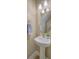 Neat bathroom with a pedestal sink, round mirror, and modern lighting fixtures at 9707 Seed St, Ladson, SC 29456