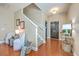 Bright foyer with wooden floors, staircase, black front door, stylish console table and a pair of cozy chairs at 9707 Seed St, Ladson, SC 29456