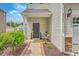 Charming front porch with a dark-colored door, side table, plants, and tasteful landscaping at 9707 Seed St, Ladson, SC 29456