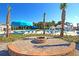 Community pool area with lounge chairs, tables, umbrellas, a splash pad, and a fire pit on a sunny day at 9707 Seed St, Ladson, SC 29456