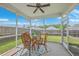 Relaxing screened porch with wicker furniture, ceiling fan, and a view of the fenced backyard at 9707 Seed St, Ladson, SC 29456