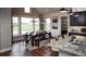Sunlit dining area featuring dark wood table and bench with large windows overlooking a green landscape at 100 Fish Rd, Ridgeville, SC 29472