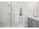 Elegant bathroom featuring a glass-enclosed shower with marble walls, a vanity with gray cabinets, and modern fixtures at 100 Hawthorne Landing Dr, Goose Creek, SC 29445