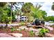 Landscaped fountain area with lush flowers, tall trees, apartment building, and brick sidewalk at 1025 Riverland Woods Pl # 106, Charleston, SC 29412