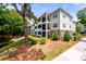 Exterior shot of the building showcasing balconies, brick accents, and manicured landscaping at 1025 Riverland Woods Pl # 106, Charleston, SC 29412