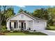 Charming single-story home with a covered front porch, two rocking chairs, and a one car garage at 1032 Scotch Bonnet Way, Summerville, SC 29485