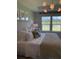 Serene main bedroom with a large window overlooking a picturesque lake and a modern light fixture at 1032 Scotch Bonnet Way, Summerville, SC 29485