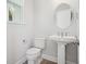 Contemporary powder room featuring a white pedestal sink, a toilet, and a round mirror at 104 Hawthorne Landing Dr, Goose Creek, SC 29445