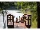 Children play with a dog on a dock by a serene lake under the shade of trees at 105 Moscato Ln, Summerville, SC 29485