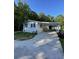Charming single-story home with a covered front porch and long driveway nestled among lush trees at 1070 French Quarter Creek Rd, Huger, SC 29450