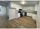 An airy kitchen boasts white cabinets, stainless appliances, granite countertops, and light wood floors at 1070 French Quarter Creek Rd, Huger, SC 29450