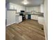 A bright kitchen features white cabinets, stainless steel appliances and new wood flooring at 1070 French Quarter Creek Rd, Huger, SC 29450