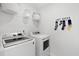 Bright laundry room with modern washer and dryer, open shelving and charming sock decor at 109 Moscato Ln, Summerville, SC 29485