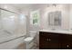 Cozy bathroom features a shower-tub combo, dark vanity, and a bright window at 114 Shadowmoss Pkwy, Charleston, SC 29414