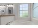 Bright bathroom featuring a large window above a soaking tub and double vanity at 114 Shadowmoss Pkwy, Charleston, SC 29414