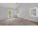 Bright bedroom with three windows, neutral carpeting, and a vaulted ceiling at 114 Shadowmoss Pkwy, Charleston, SC 29414
