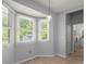 Bright breakfast nook with a modern light fixture with three windows overlooking the outdoors at 114 Shadowmoss Pkwy, Charleston, SC 29414