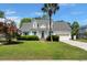 Charming two-story home featuring a well-manicured lawn, blue shutters, and a welcoming front porch at 114 Shadowmoss Pkwy, Charleston, SC 29414