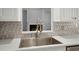 Bright kitchen featuring a stainless steel sink with a fireplace view and decorative backsplash at 114 Shadowmoss Pkwy, Charleston, SC 29414