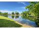 Scenic view of a tranquil pond surrounded by lush greenery and neighborhood homes at 114 Shadowmoss Pkwy, Charleston, SC 29414