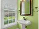 Charming powder room featuring a pedestal sink, decorative mirror and bright window at 114 Shadowmoss Pkwy, Charleston, SC 29414
