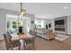 Stylish dining area with modern lighting, comfortable seating, and an open view to the cozy living room with fireplace at 114 W Bradford Pointe Dr, Summerville, SC 29483